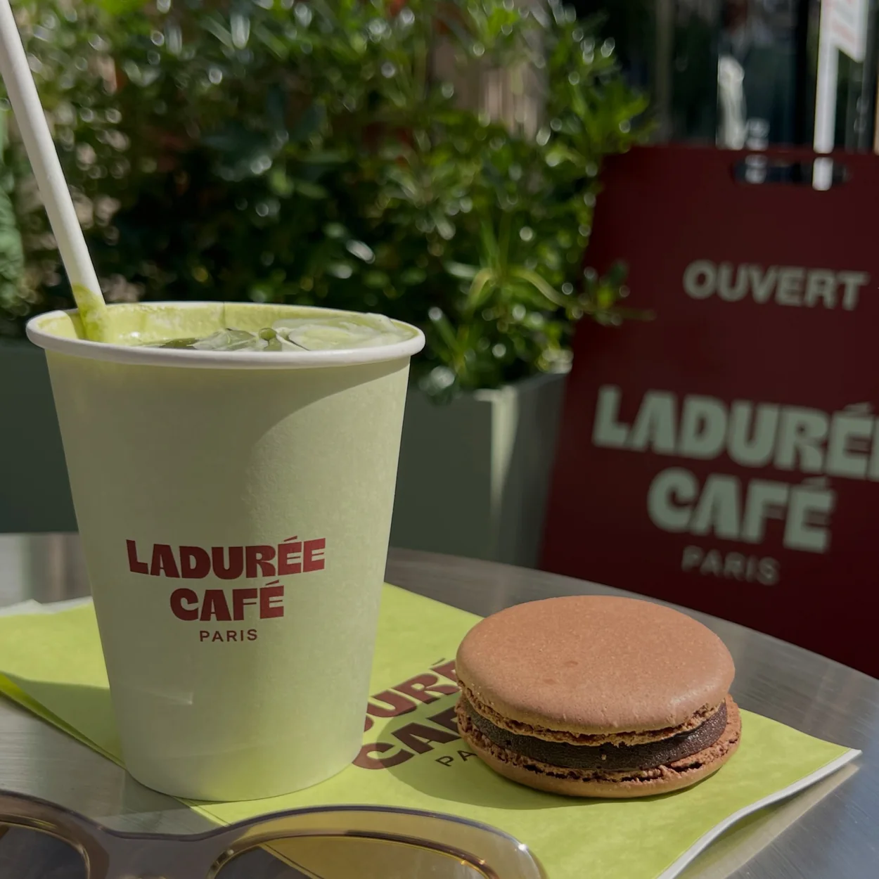 Ladurée Covent Garden iced matcha and a macaron at an outdoor table