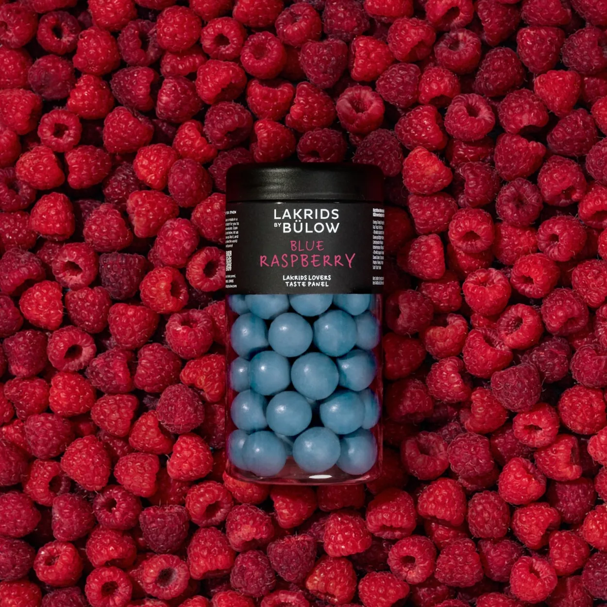 Lakrids by Bülow raspberry liquorice jar on a bed of raspberries