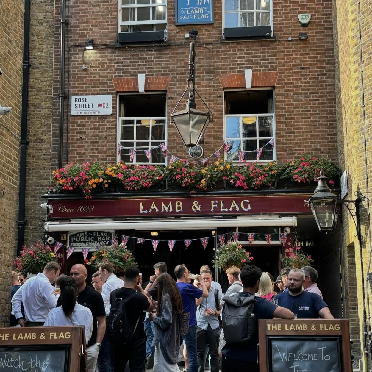 Drinkers gathered outside the Lamb & Flag on Rose Street beneath the hanging baskets