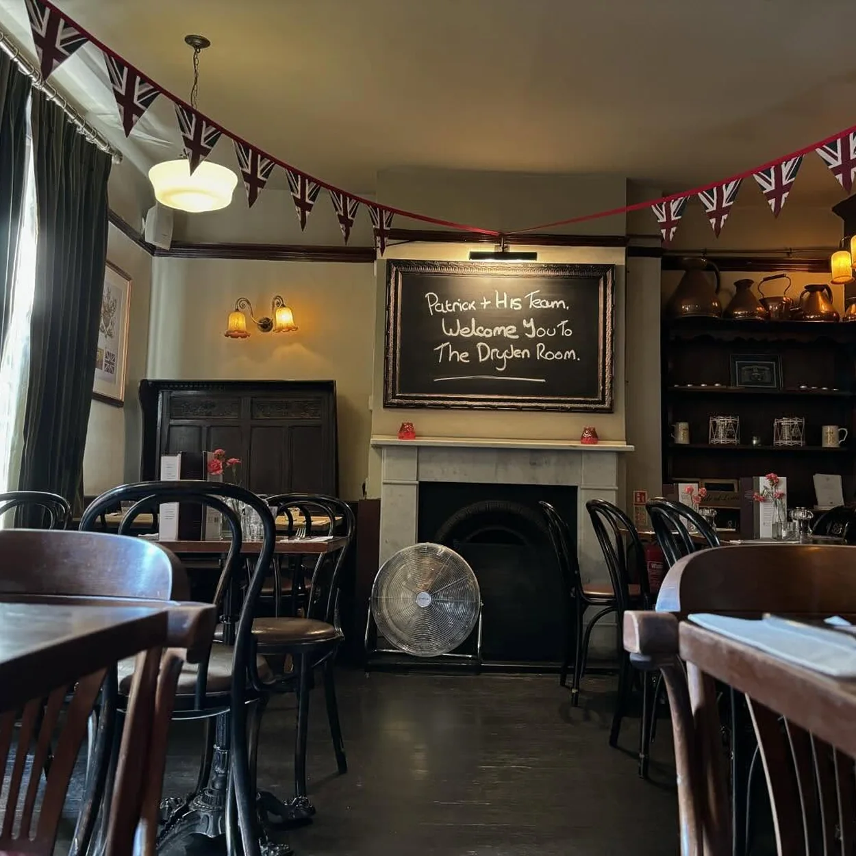 Upstairs room at the Lamb & Flag with its fireplace and wooden tables