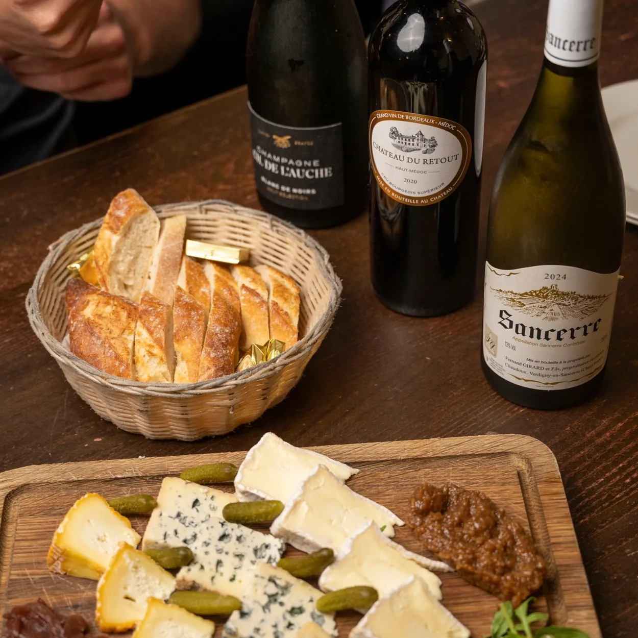 Le Garrick French cheese board with bread and bottles of Sancerre