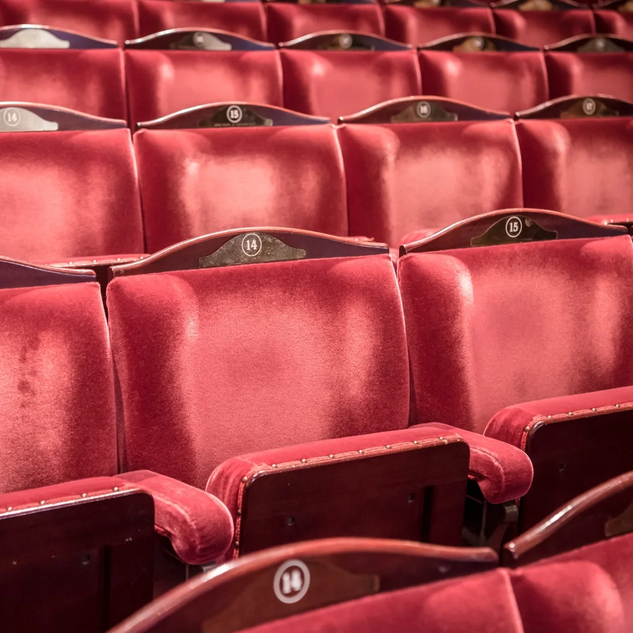 Rows of red velvet seats inside the London Coliseum