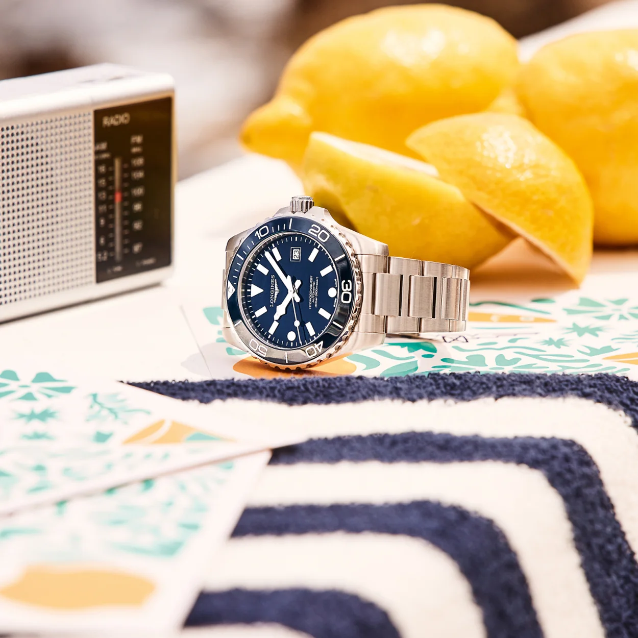 Longines blue-dial steel sports watch on a summer table