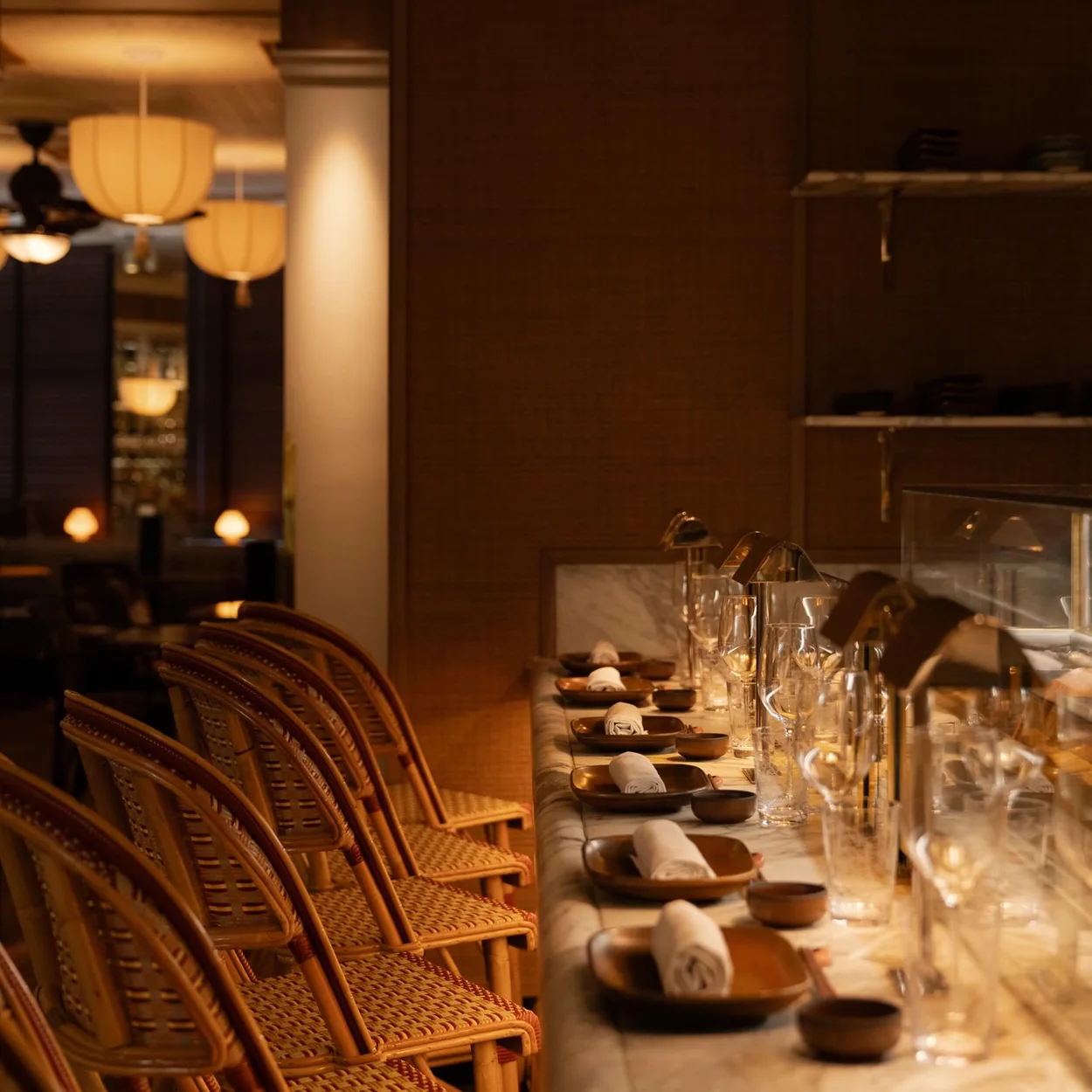Louie dining room with bistro chairs and laid tables under warm lighting