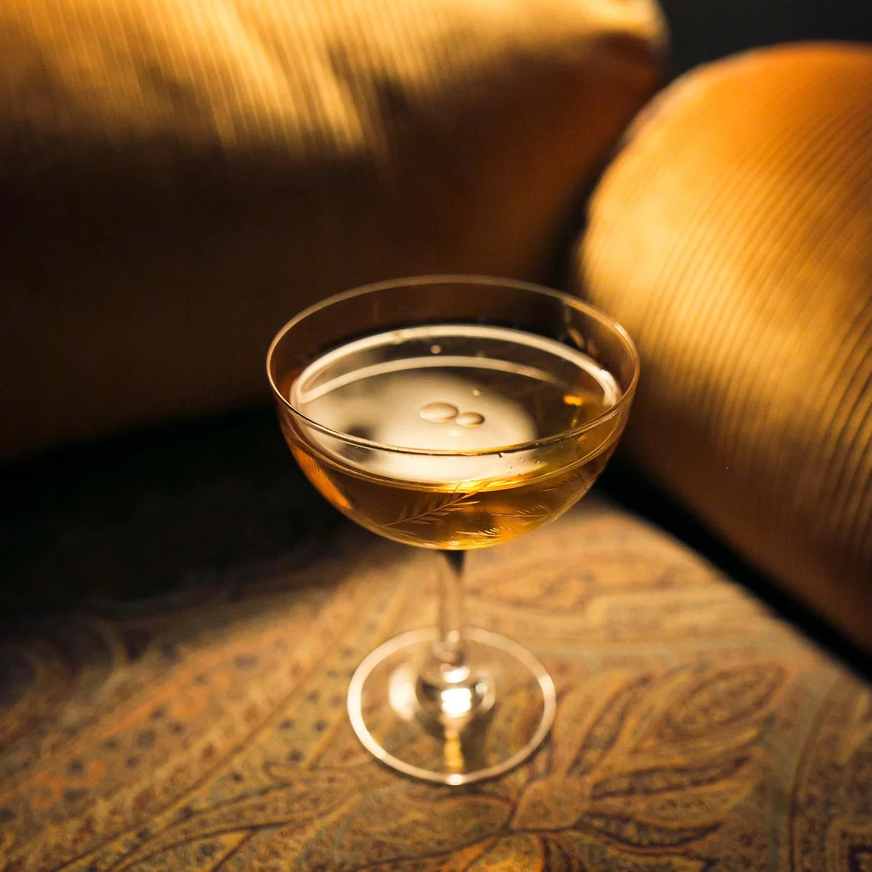 Louie coupe cocktail on a velvet banquette