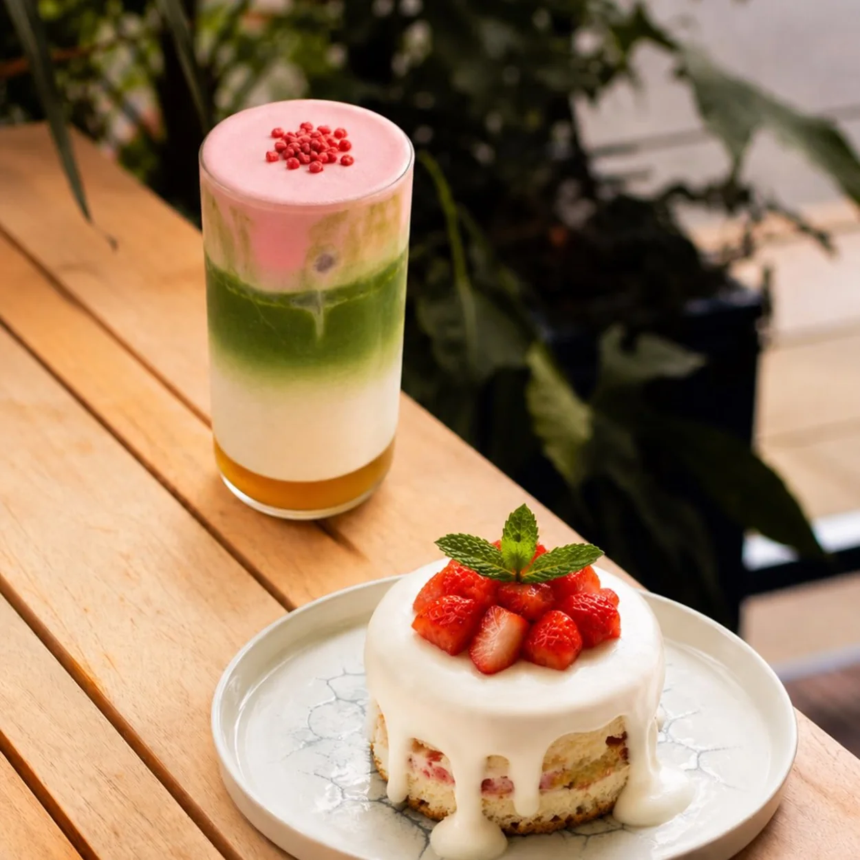 Matchamisu strawberry tiramisu and a layered iced matcha on a terrace table