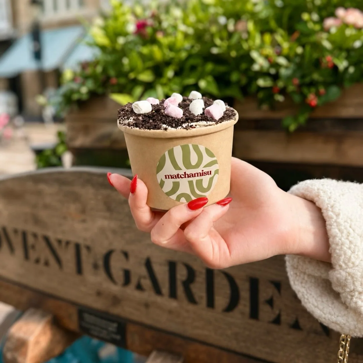 Matchamisu tiramisu cup held in front of the Covent Garden Market sign