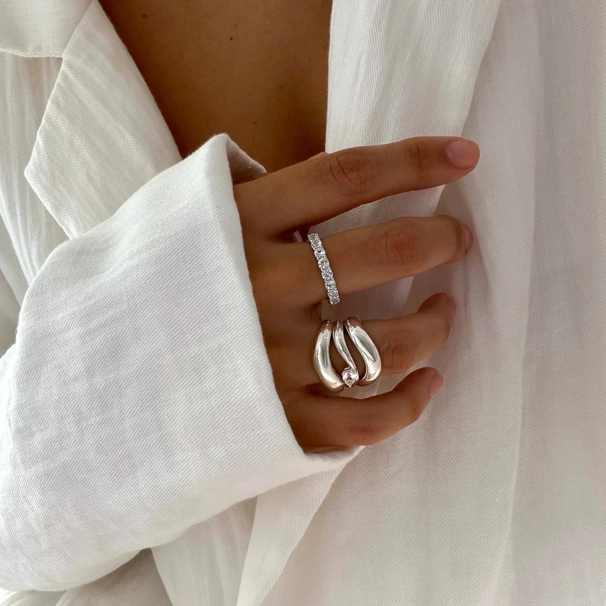 Mejuri silver and diamond rings worn with a white shirt