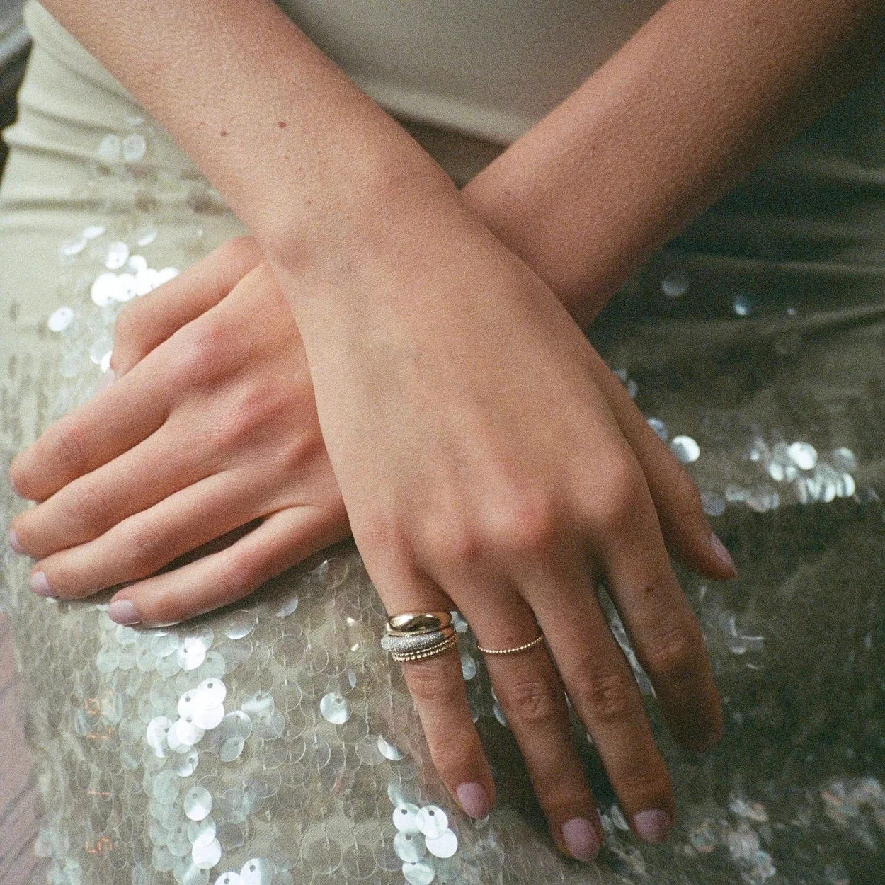 Mejuri gold rings worn with a sequinned skirt