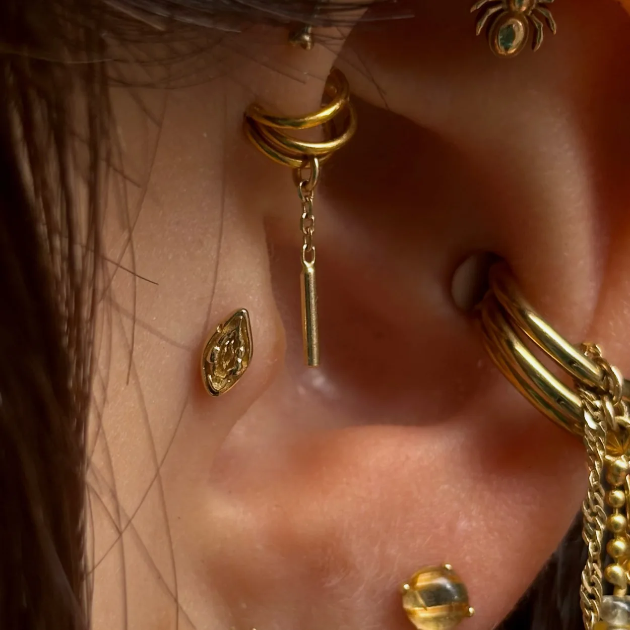 Metal Morphosis curated ear with gold hoops, chains and charms