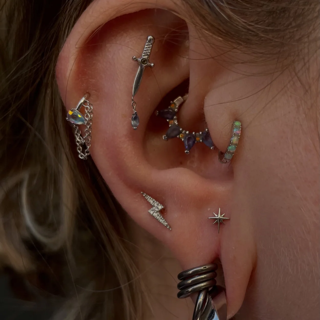 Metal Morphosis ear stack with dagger, lightning and opal studs