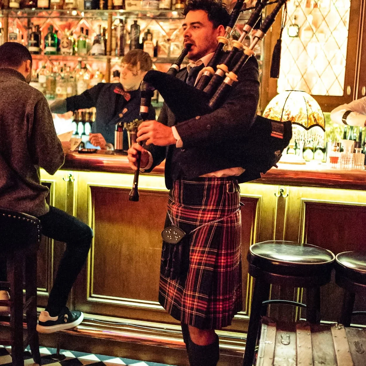 Mr Fogg's Society of Exploration bar with a bagpiper playing beside the back bar