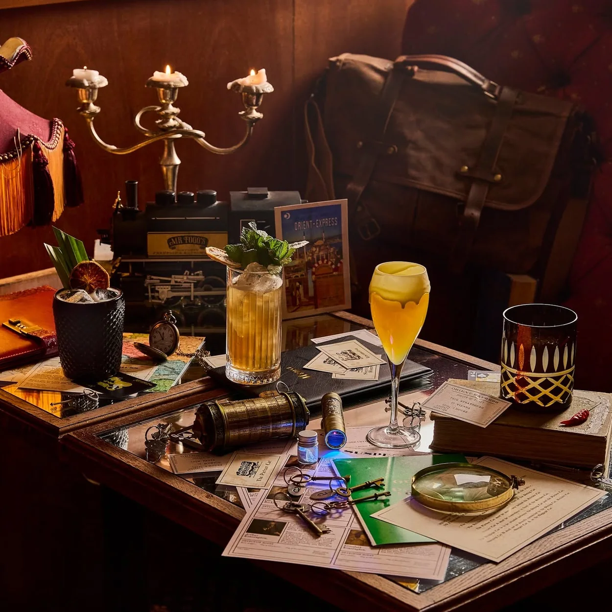 Mr Fogg's Society of Exploration table set with cocktails, candelabra and explorer props