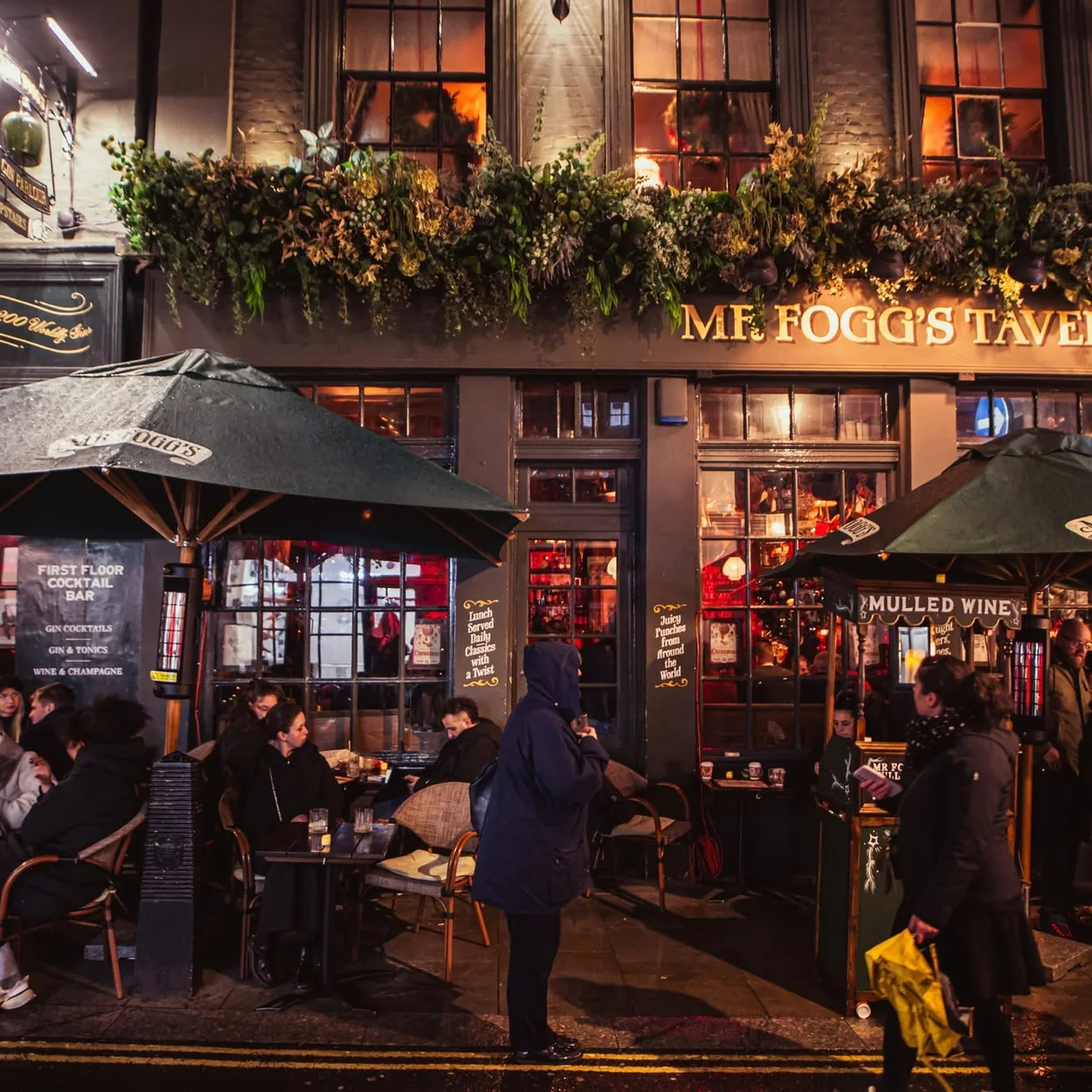 Mr Fogg's Tavern exterior with green parasols and outdoor tables on St Martin's Lane