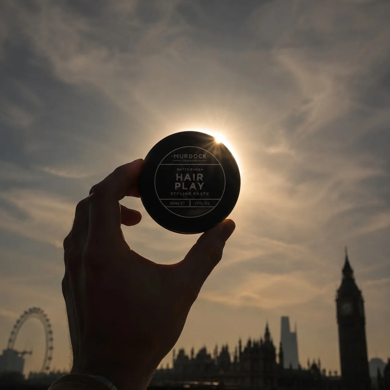 Murdock London hair play pot held up against the London skyline