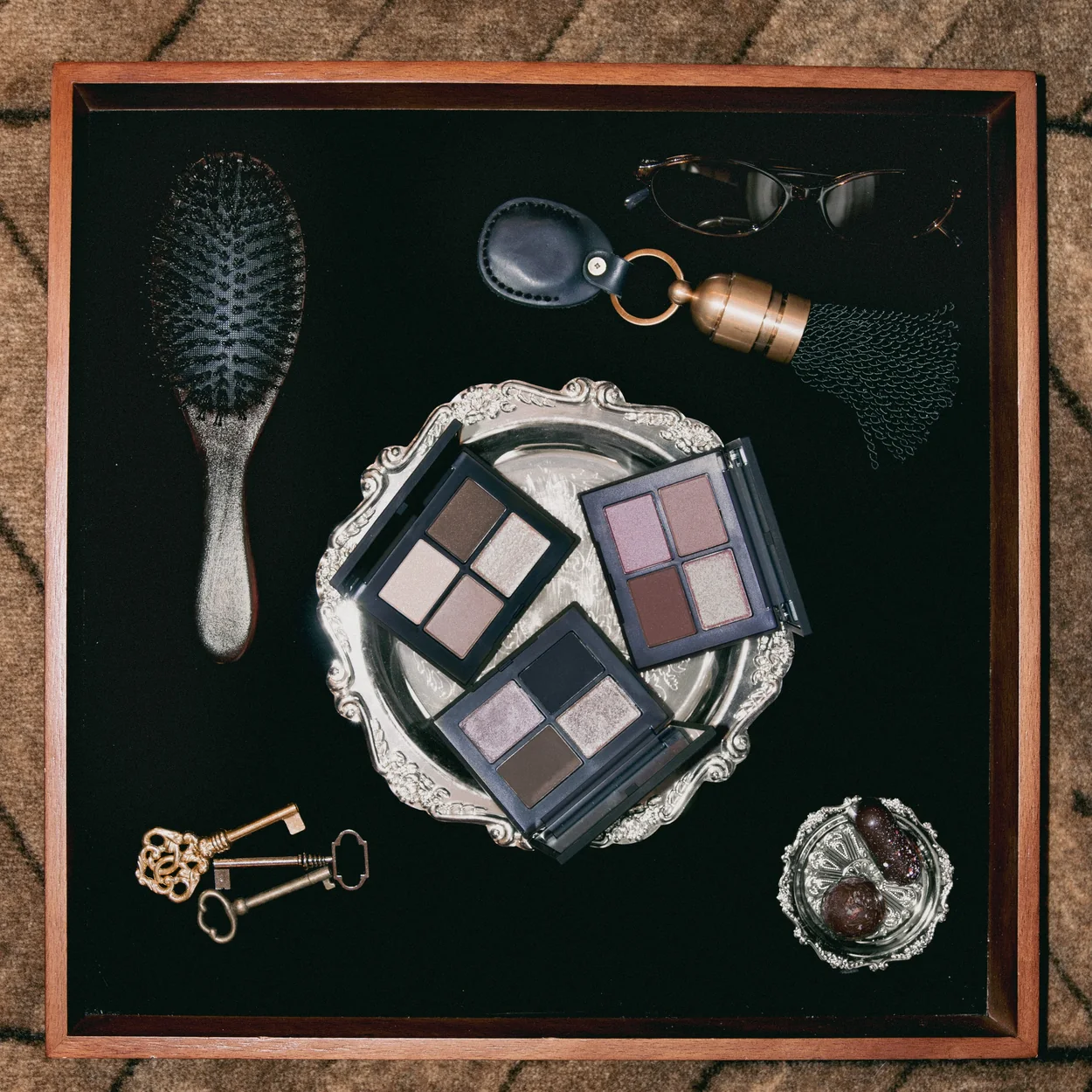 NARS eyeshadow palette and accessories laid out on a velvet tray