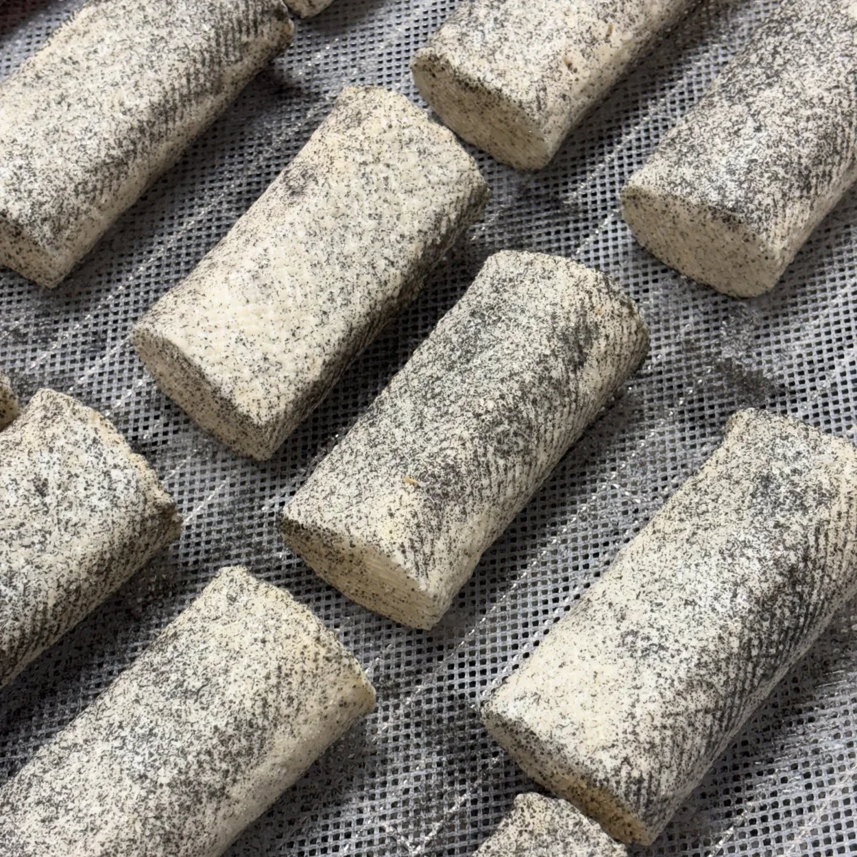 Neal's Yard Dairy ash-coated goat's cheese logs maturing