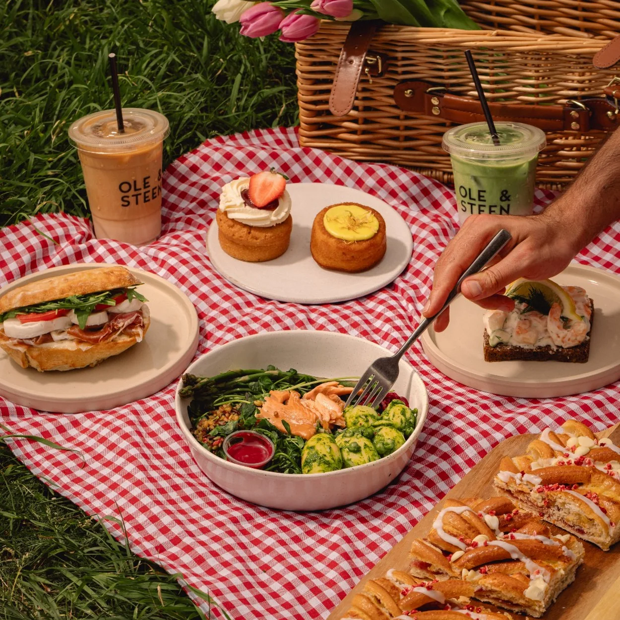 Ole & Steen pastries, sandwiches and iced drinks on a picnic blanket