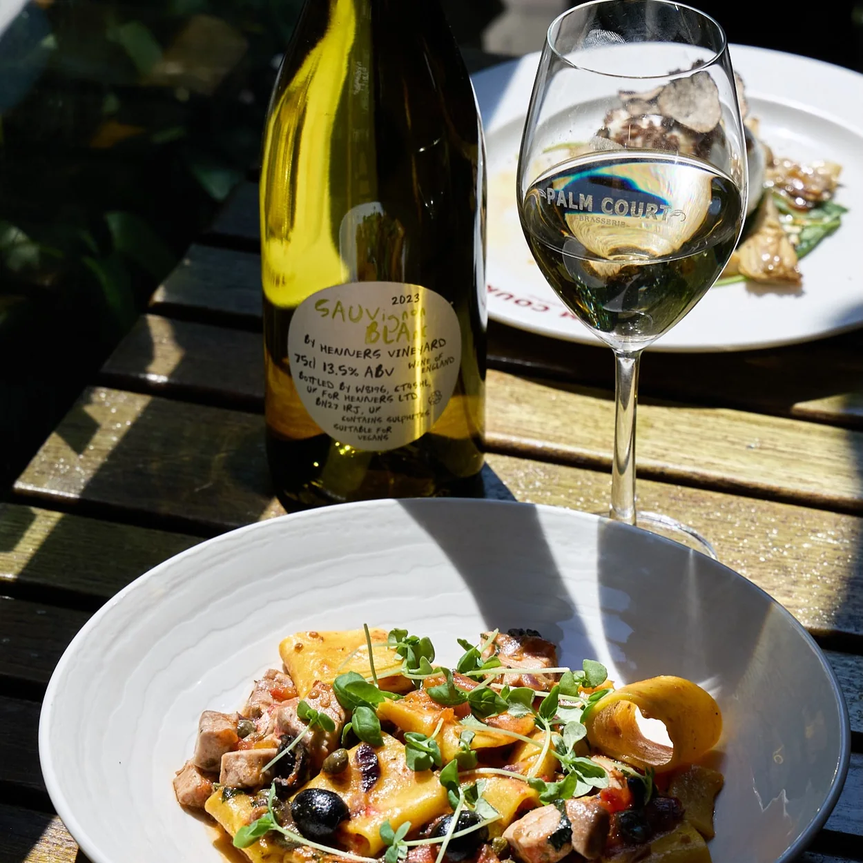 Palm Court Brasserie pasta and white wine on a pavement table