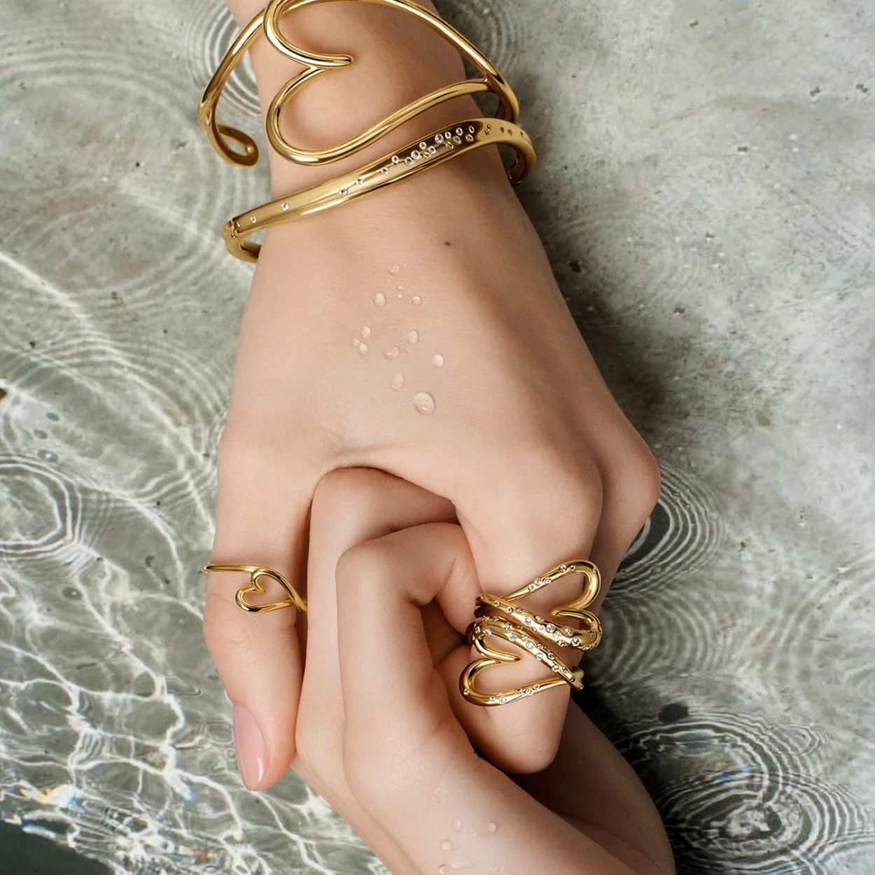 Pandora gold-tone sculpted bangles and rings worn together