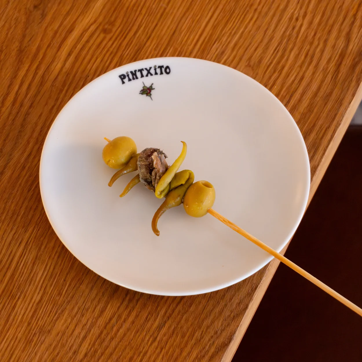 Pintxito gilda pintxo of olive, anchovy and guindilla on a branded plate