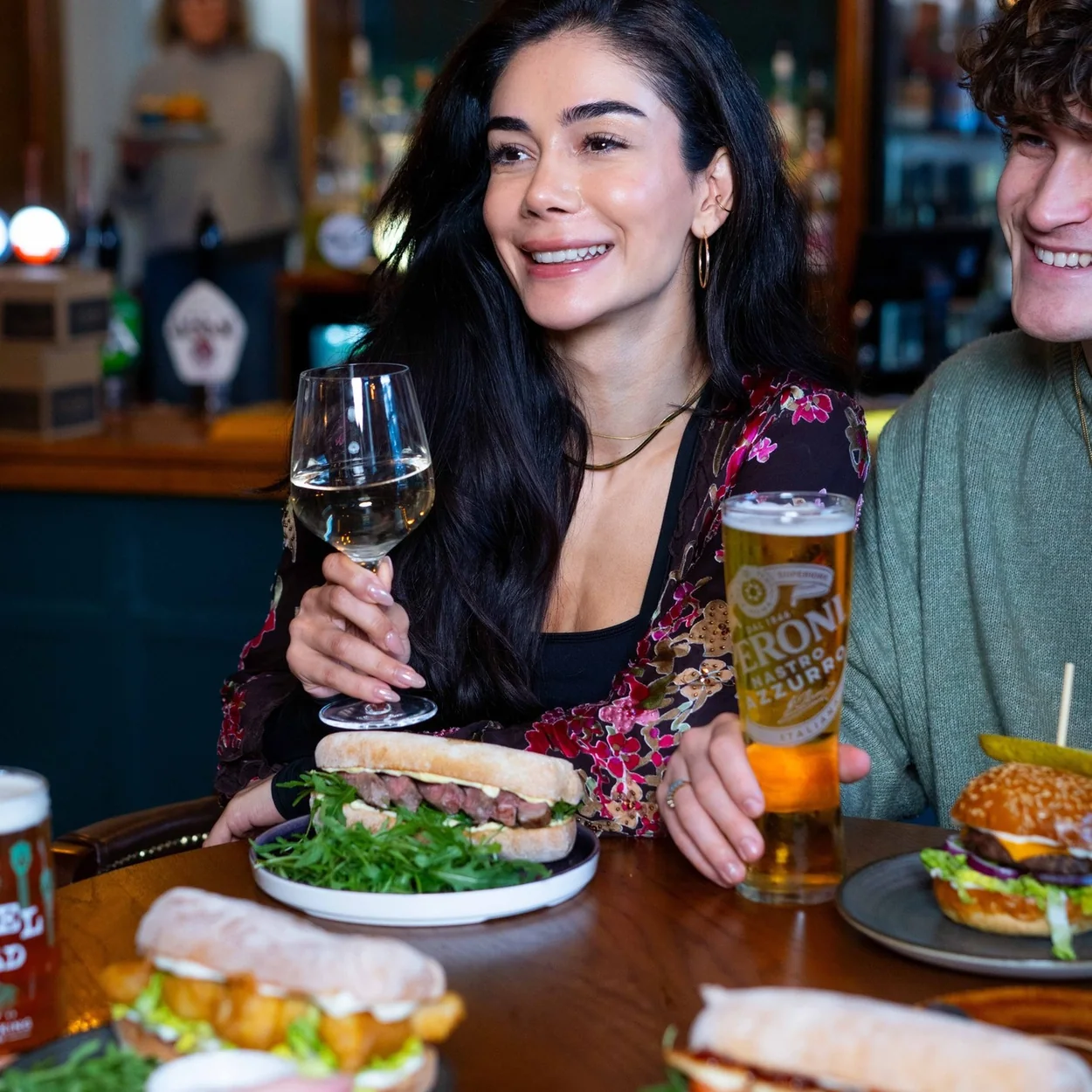 Friends sharing burgers, sandwiches and drinks at the Prince of Wales, Covent Garden
