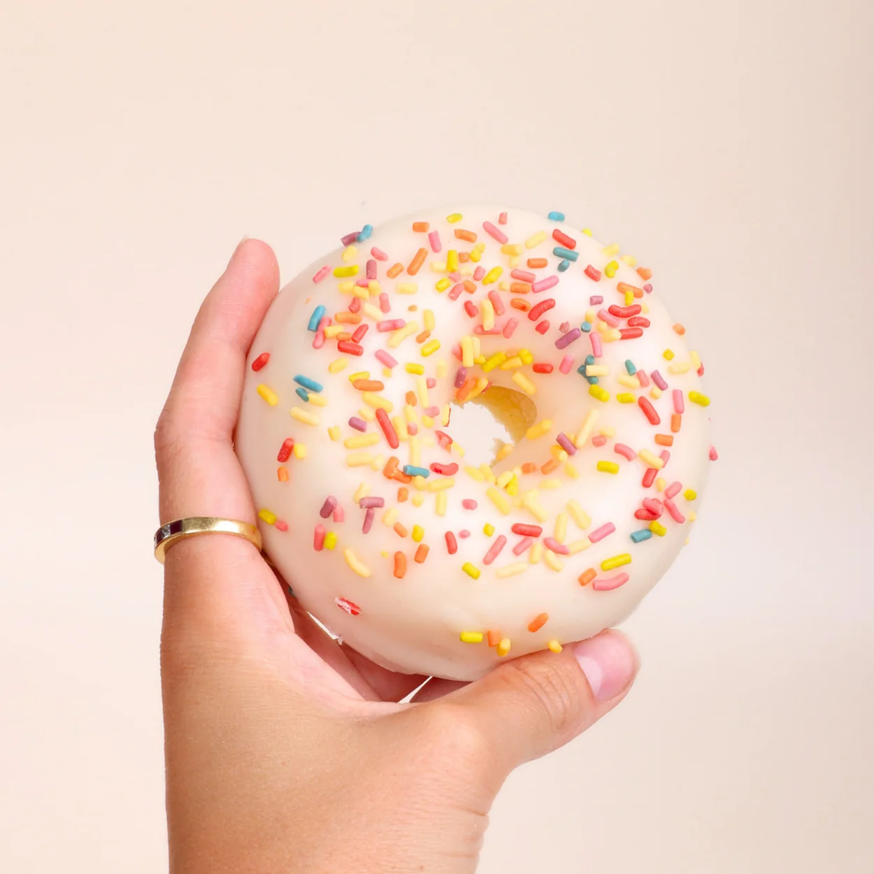 Rodeo Doughnuts sprinkle-topped glazed doughnut held in hand