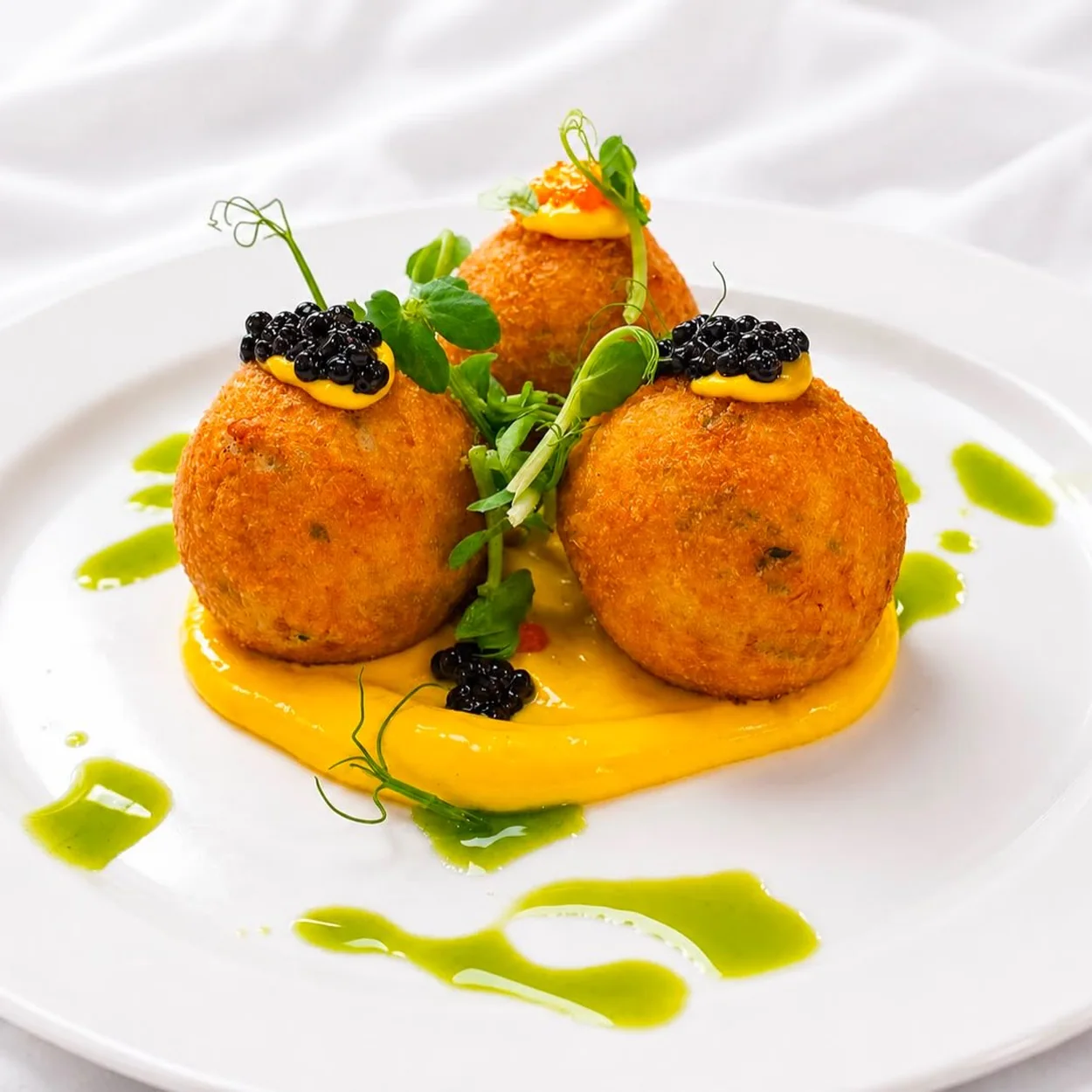 Rules arancini topped with caviar on a saffron sauce
