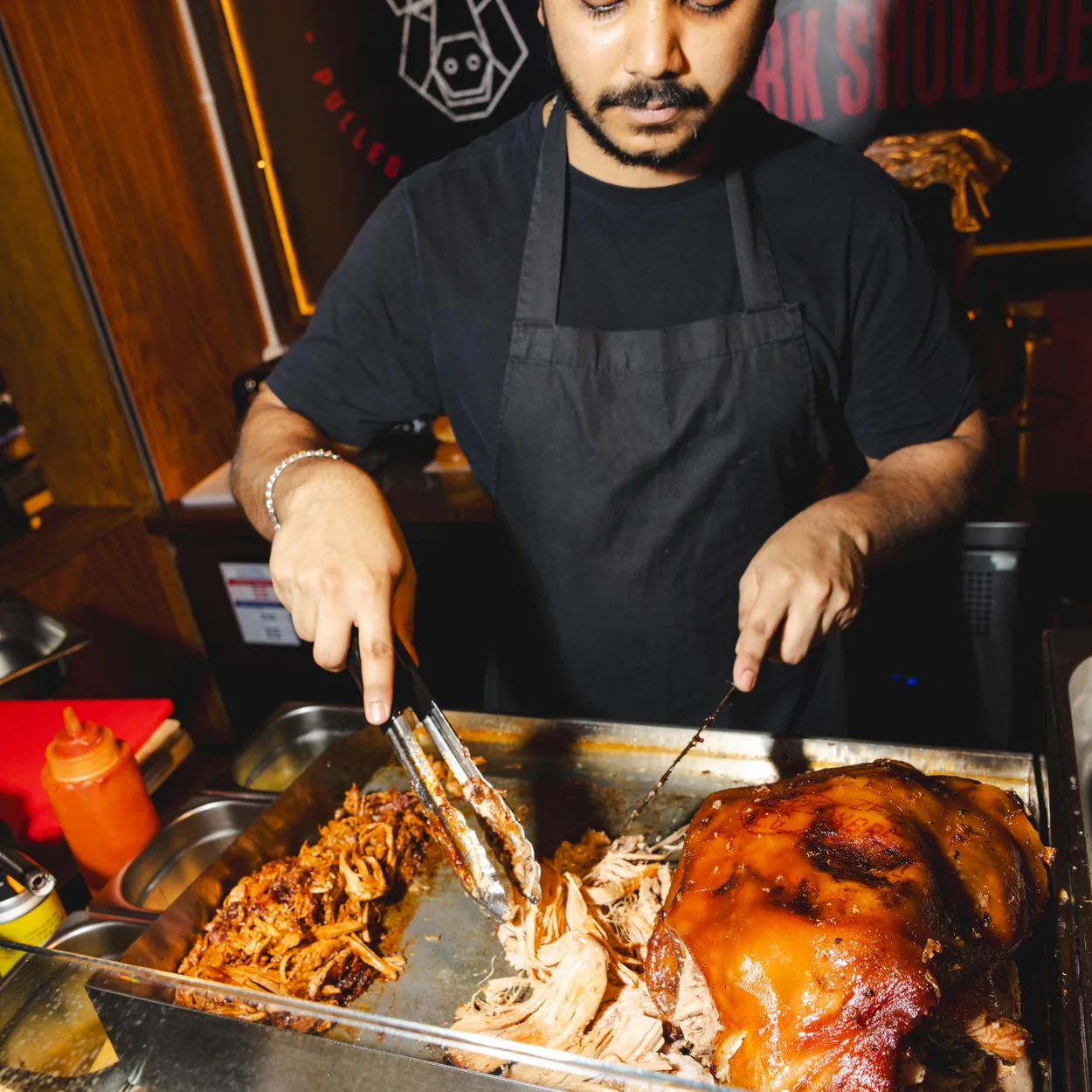 Seven Dials Market trader carving roast pork at a food hall counter