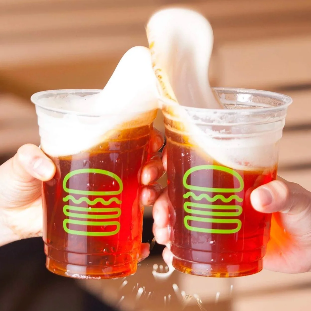 Shake Shack Covent Garden branded cups of beer clinking together
