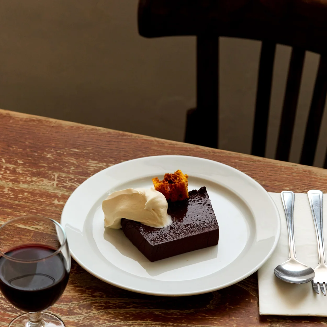 St. JOHN chocolate cake with cream and a glass of red wine