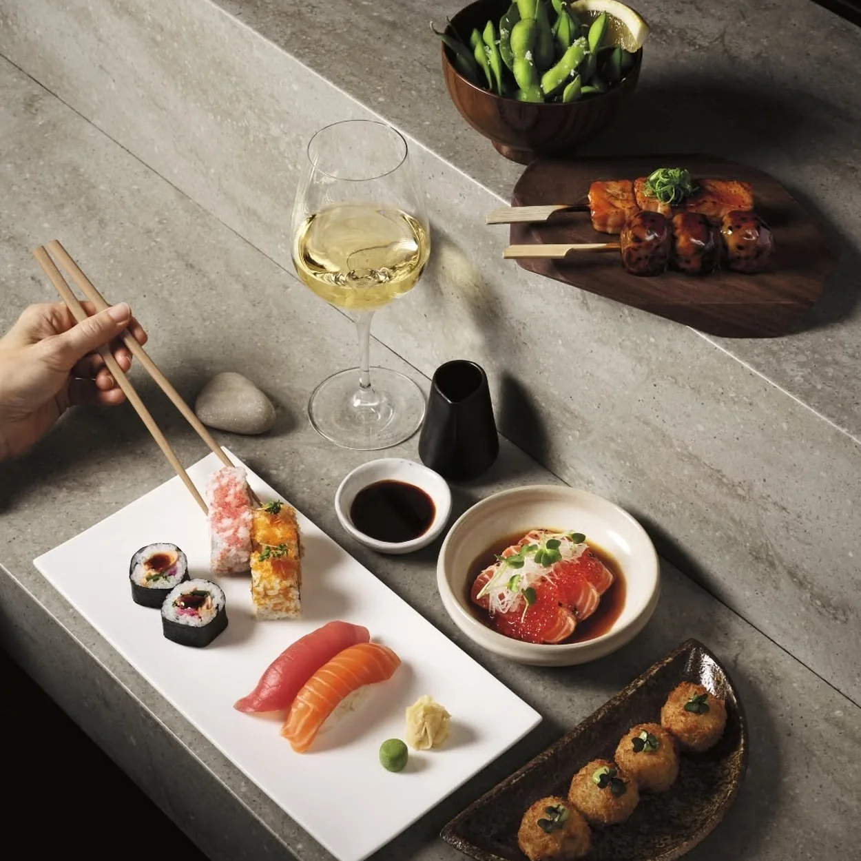 Sticks'n'Sushi sushi plate with sticks, edamame and a glass of wine