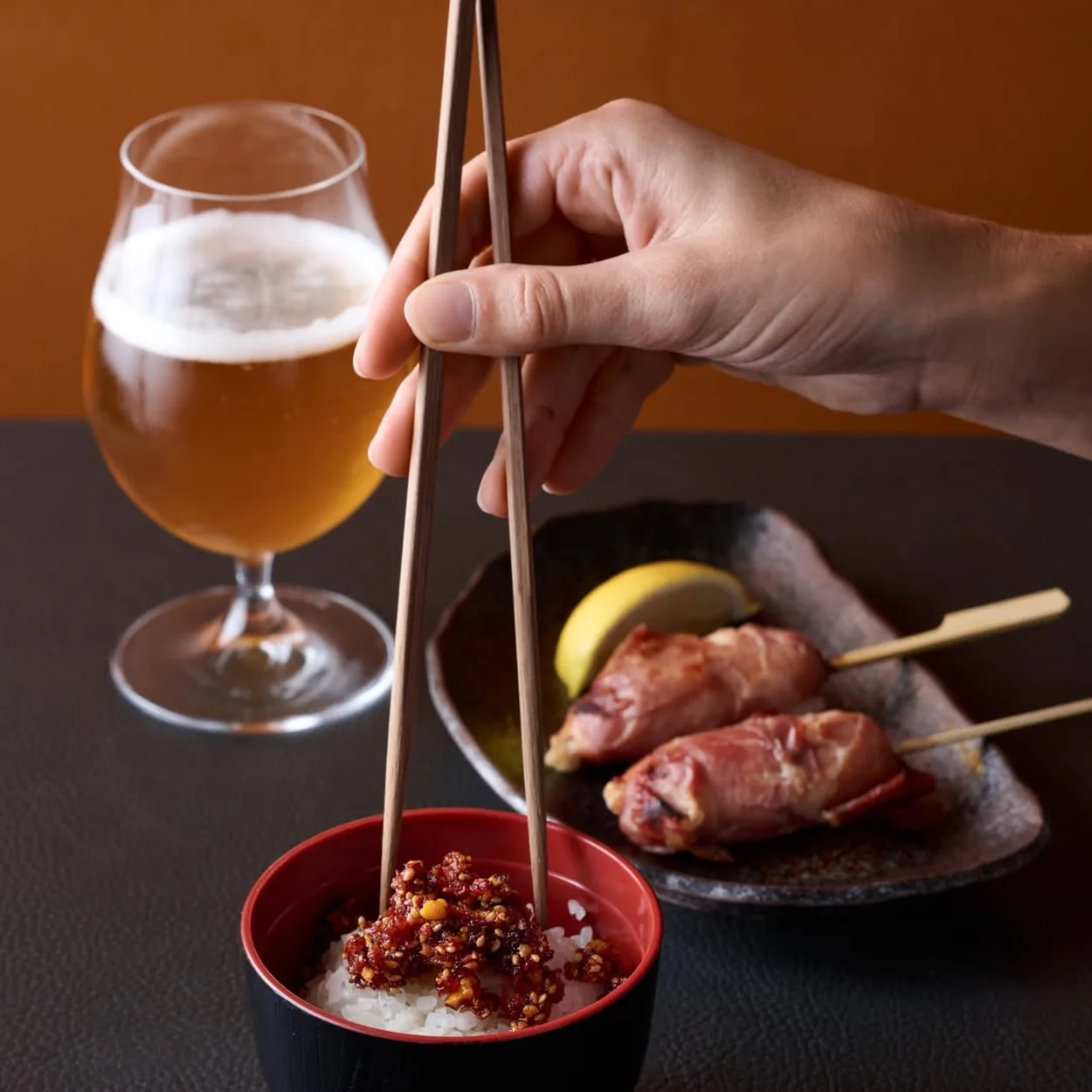 Sticks'n'Sushi grilled stick over rice with a glass of beer