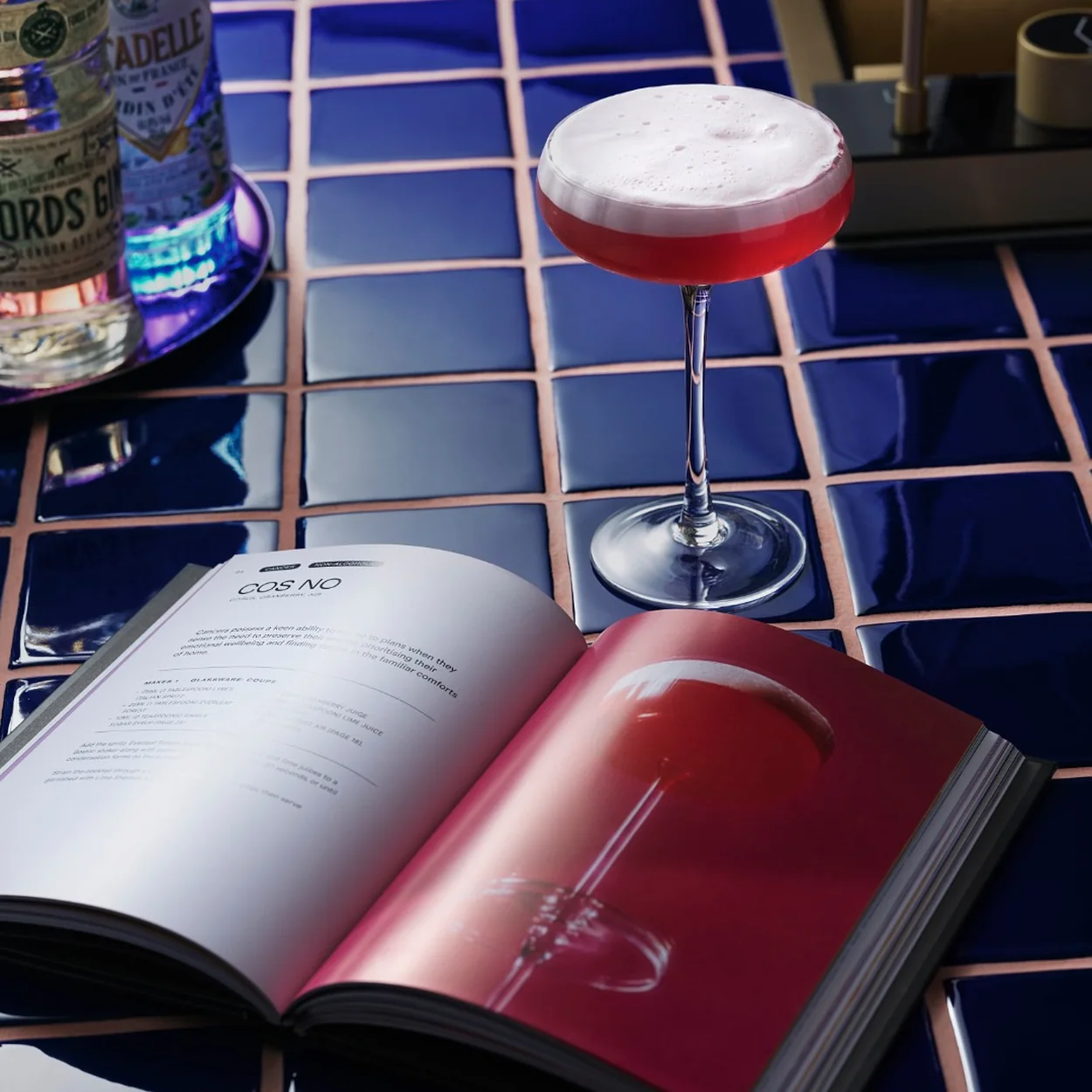 The Alchemist St Martin's Lane cocktail served beside the open drinks menu