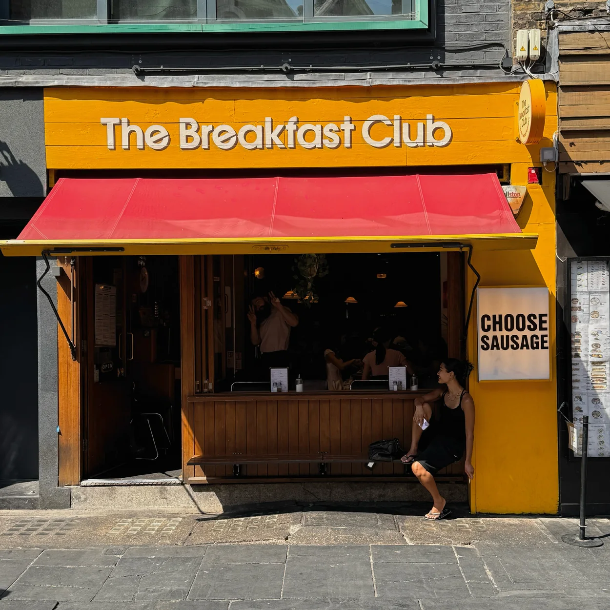 The Breakfast Club yellow shopfront with red awning