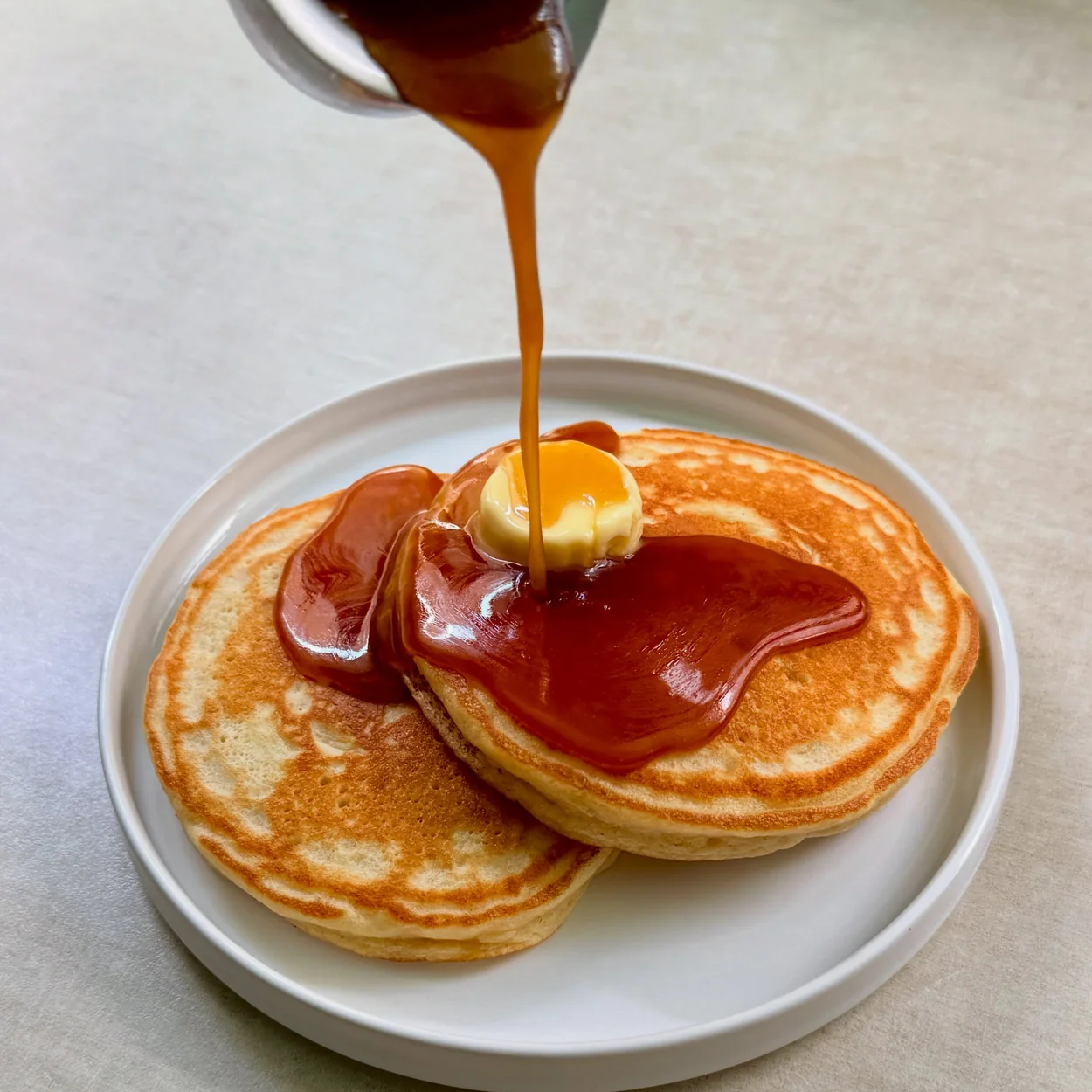 The Breakfast Club pancakes with maple syrup being poured