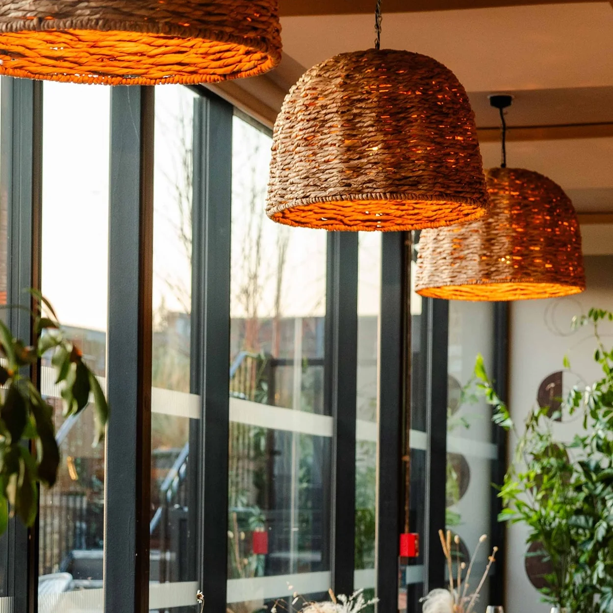 The Conduit lounge interior with woven pendant lamps and tall windows