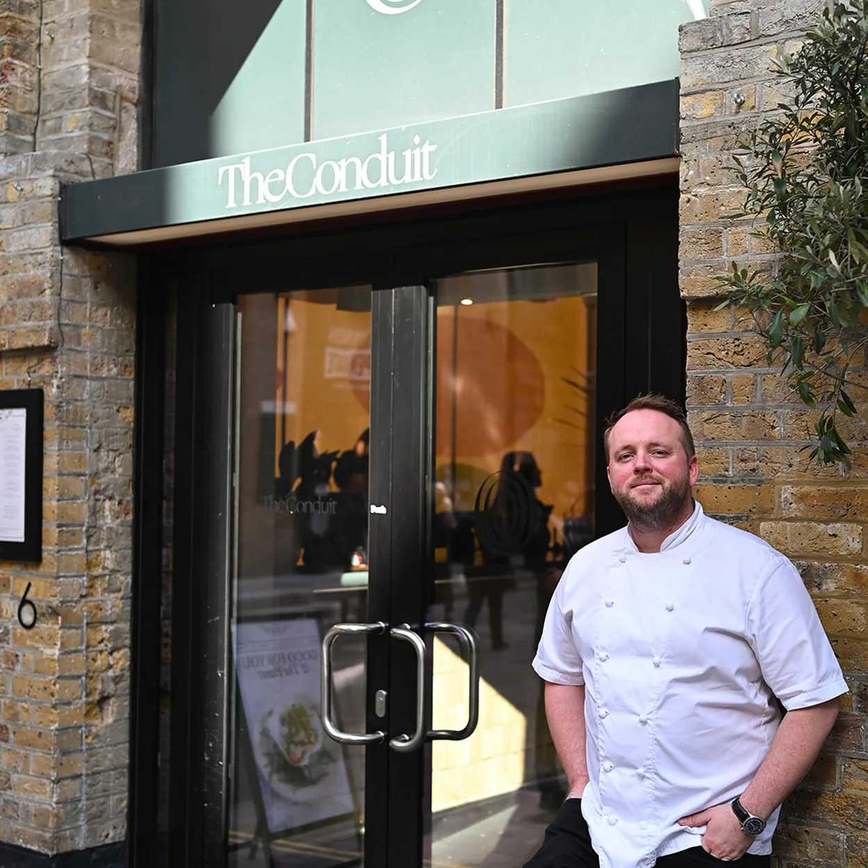 The Conduit entrance on Langley Street with a chef at the door