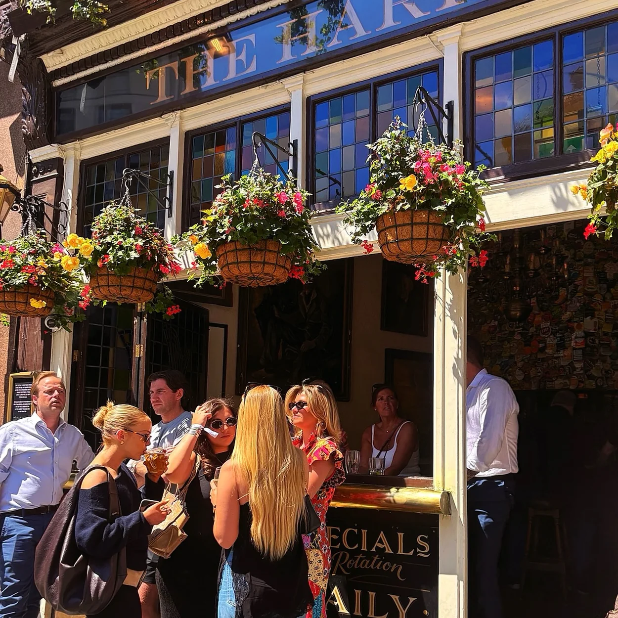 Drinkers outside The Harp on Chandos Place on a summer evening