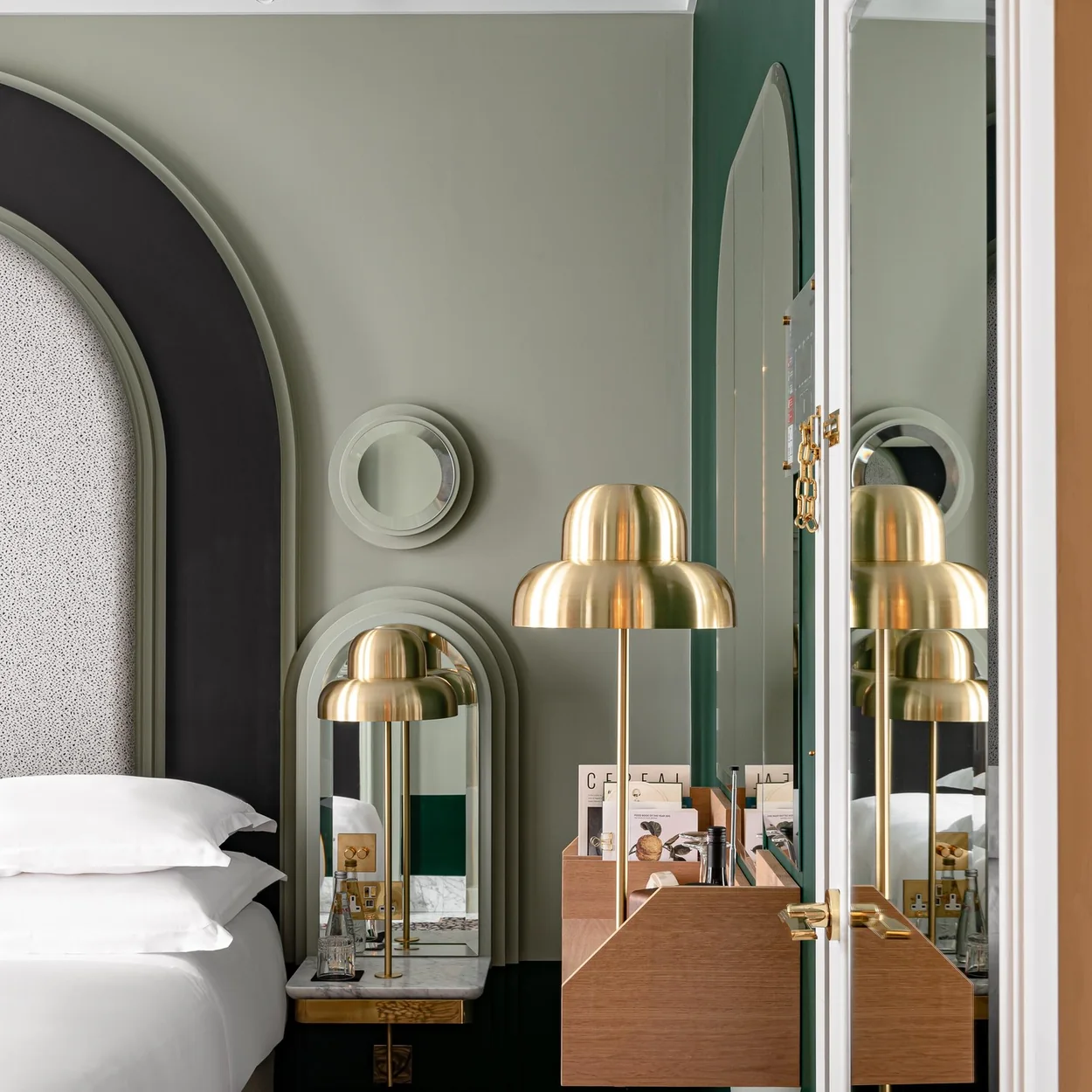 Henrietta Hotel room with mirrored alcove and brass lamps