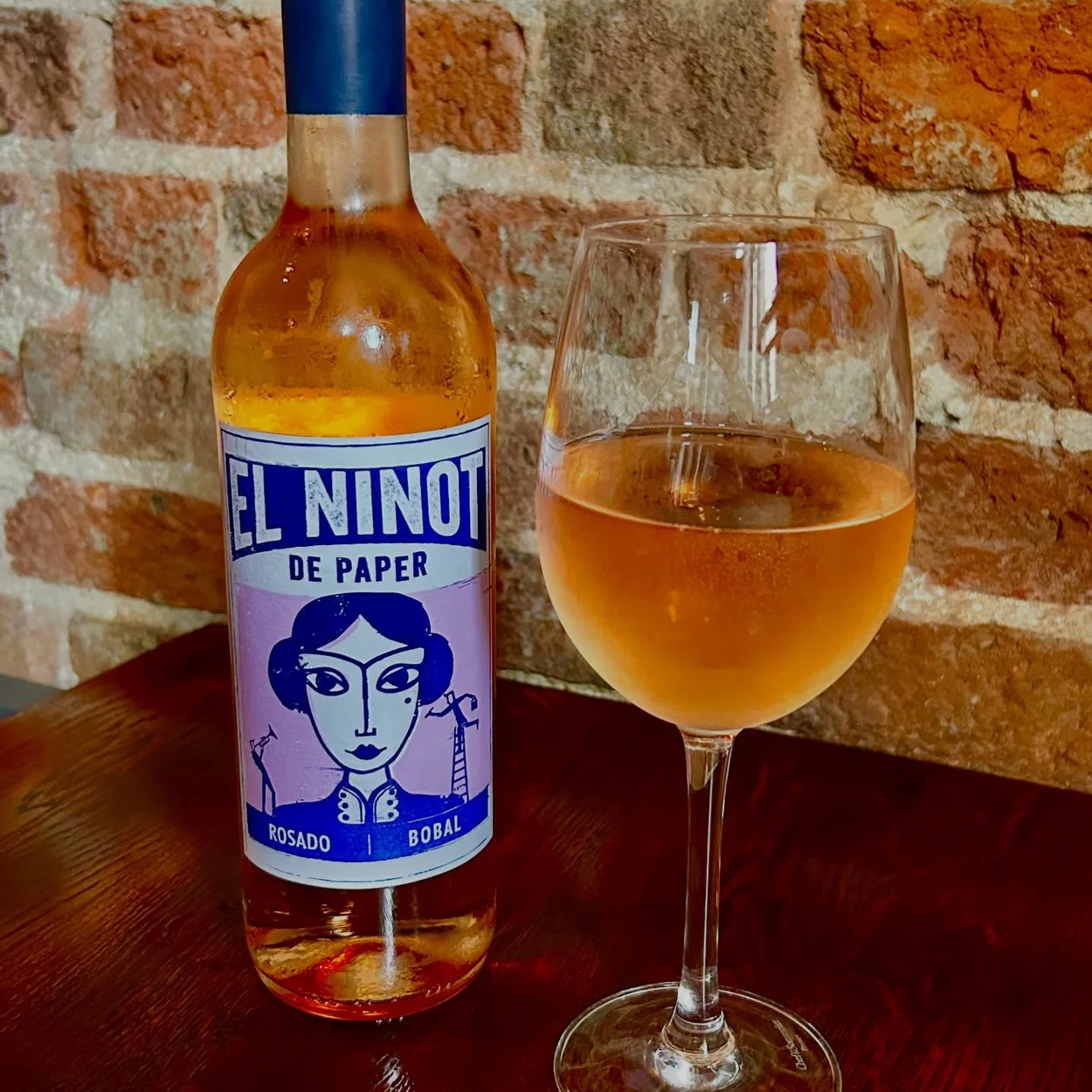 The Port House glass of rosé against the brick wall
