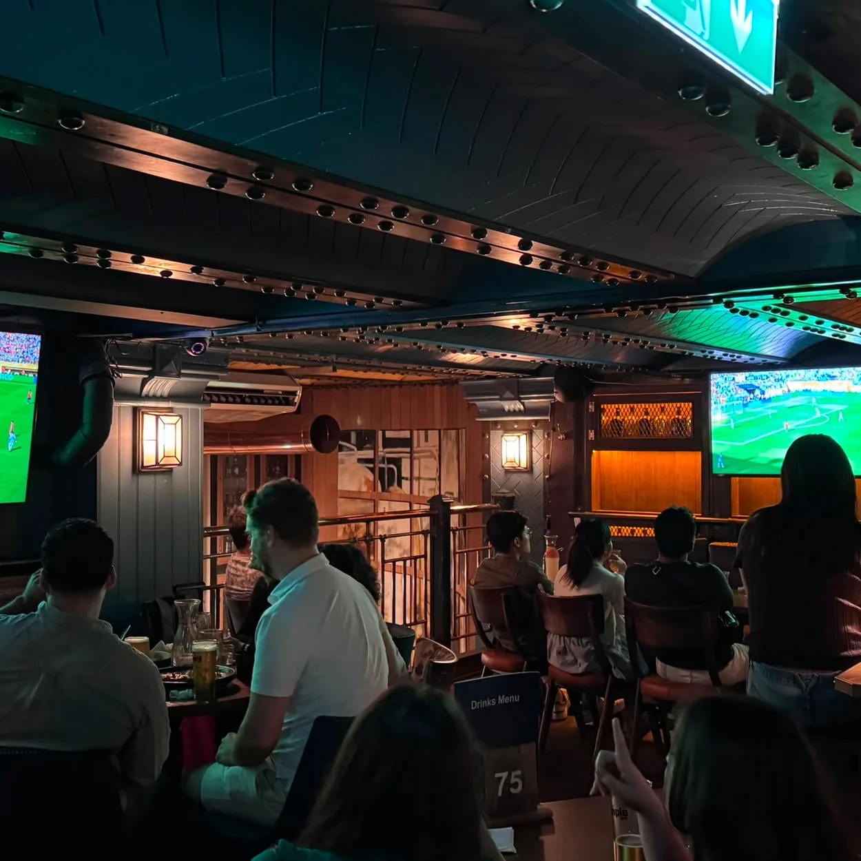 Customers watching live football on the screens at The Porterhouse, Covent Garden