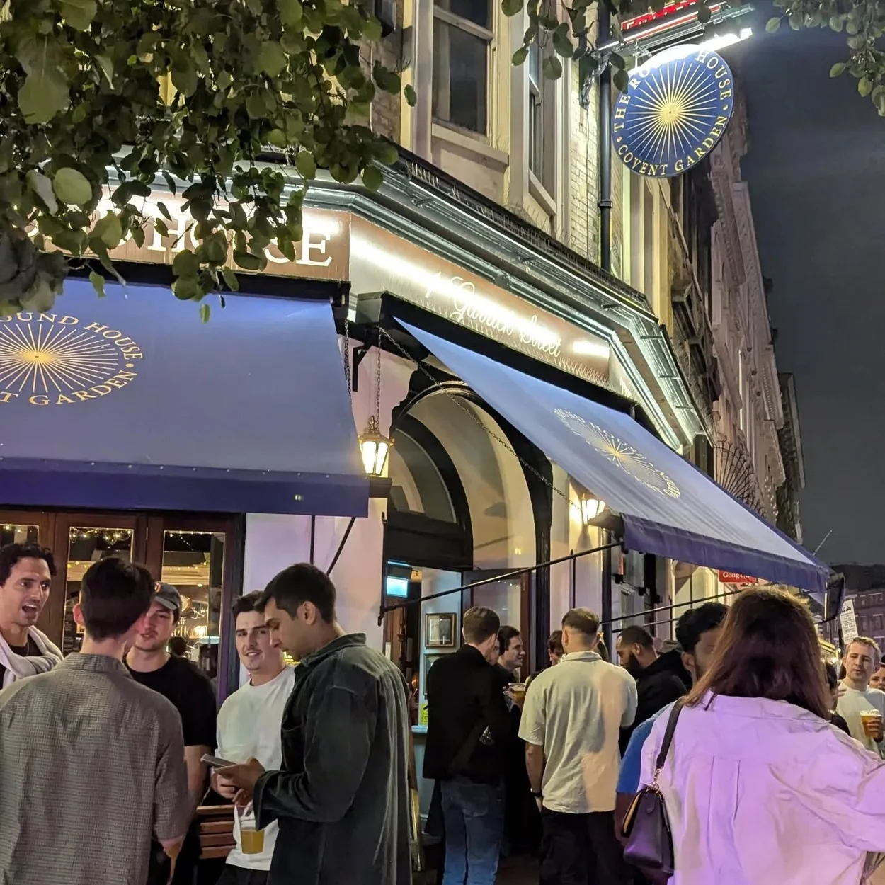The Round House exterior in the evening with drinkers outside