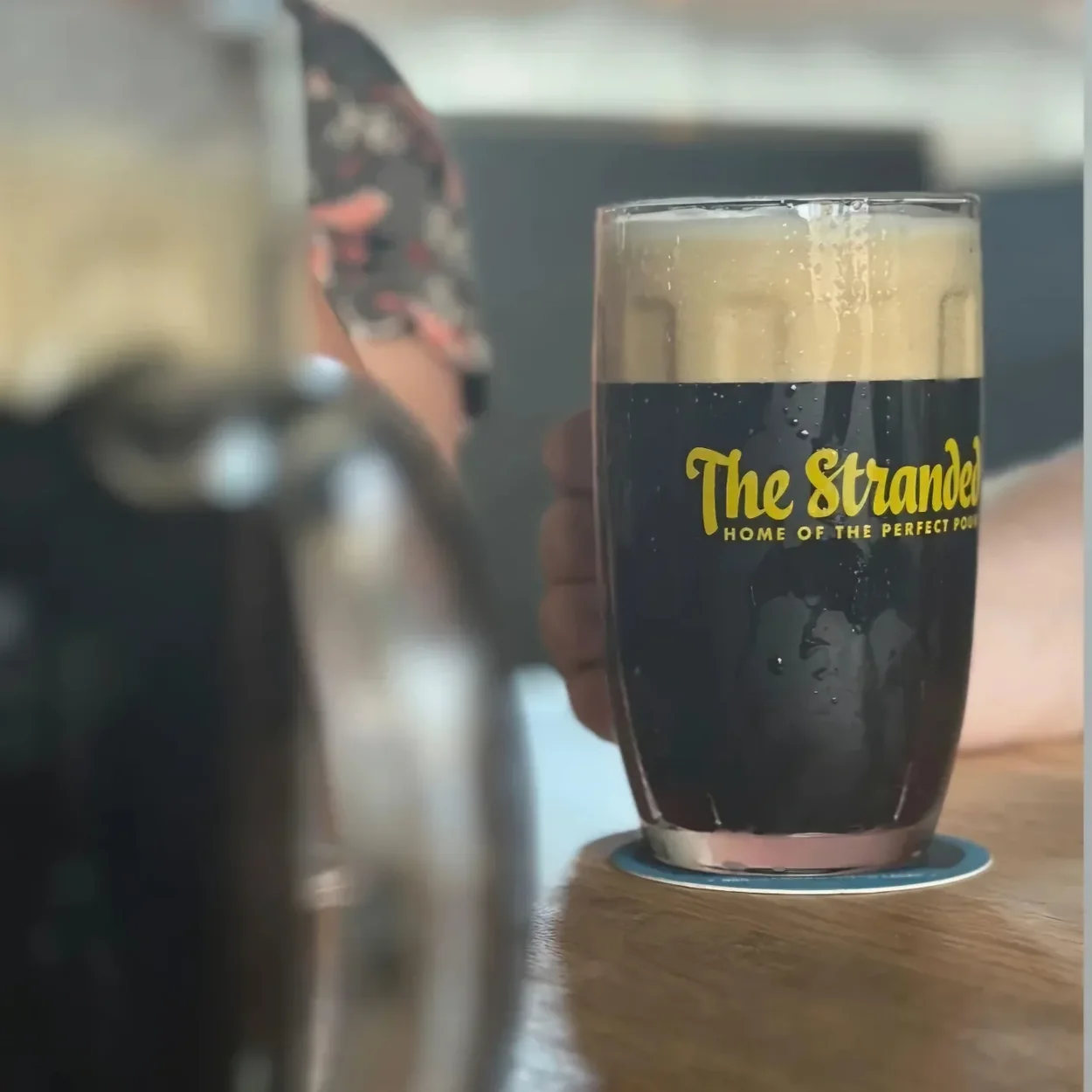 The Stranded branded glass of dark lager with dense foam