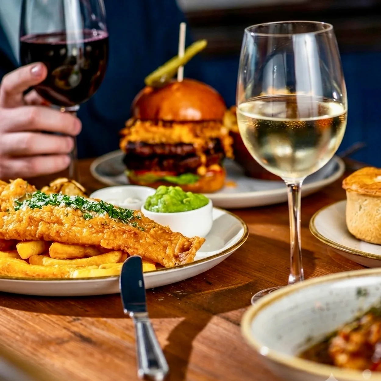 The White Lion fish and chips, burger and wine on a pub table