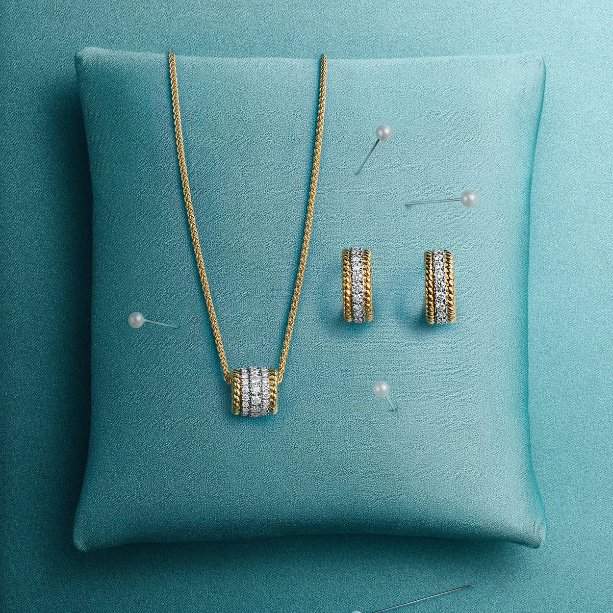 Tiffany & Co. diamond pendant necklace and hoop earrings on a Tiffany Blue cushion