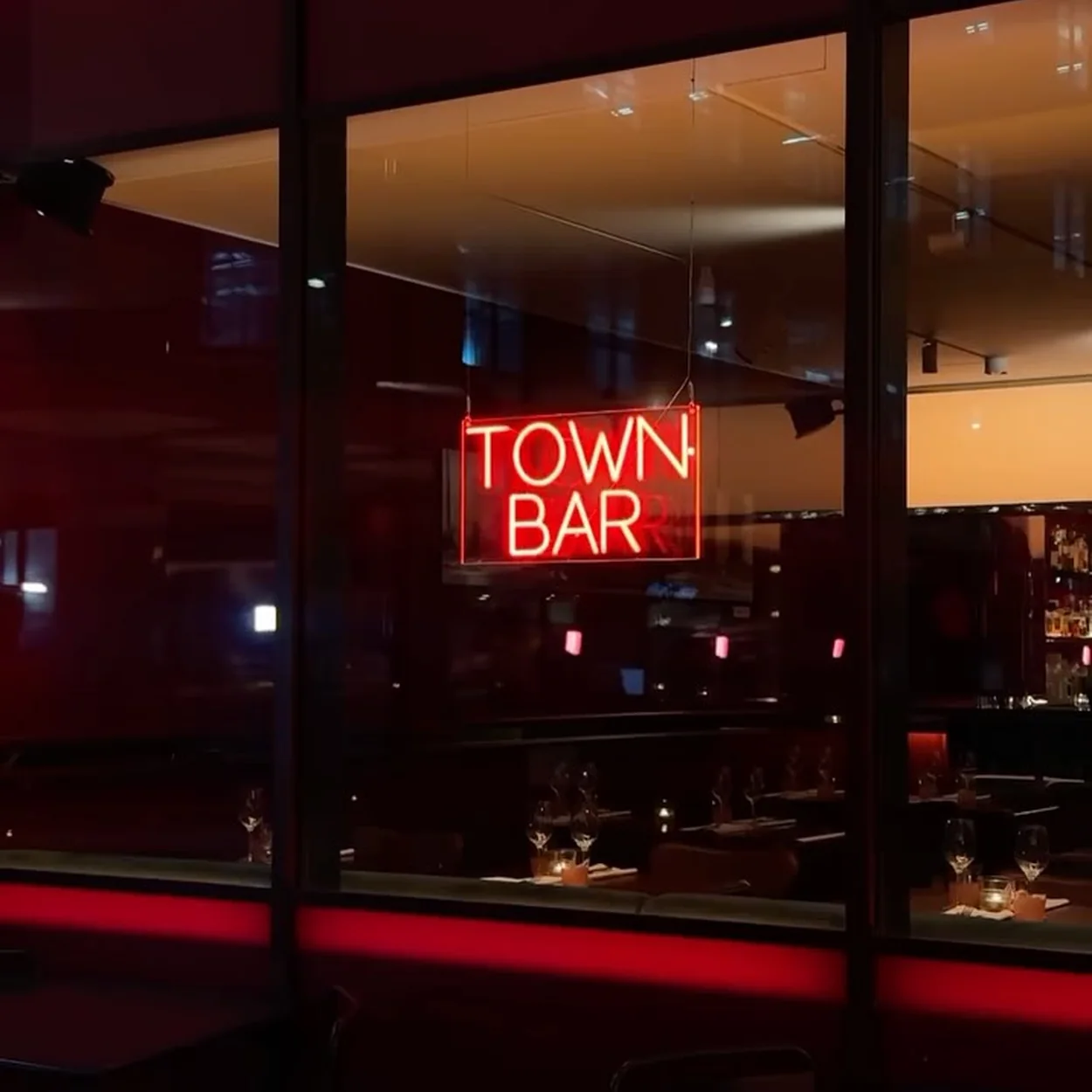 Town Bar neon sign seen through the window on Drury Lane at night