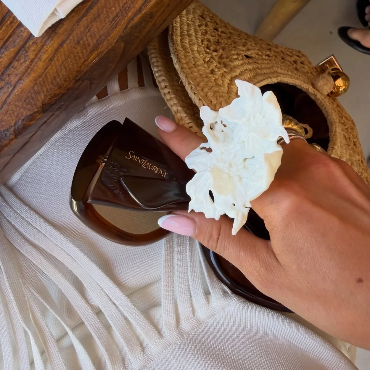 Townhouse pink manicure holding a white flower and sunglasses