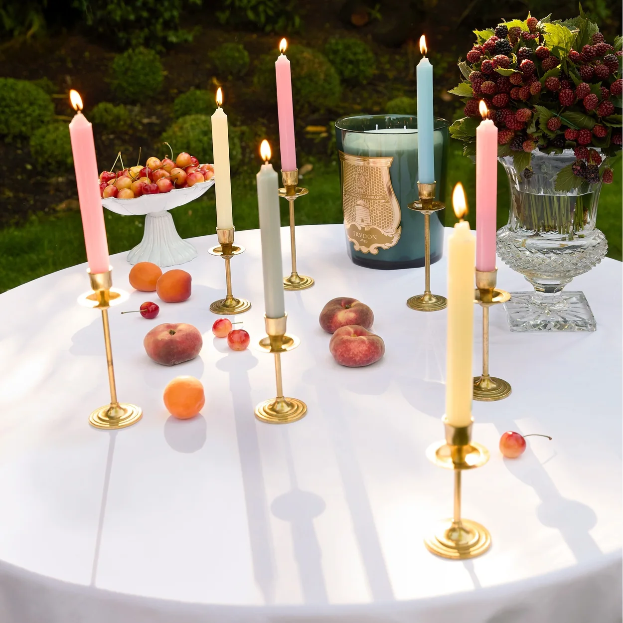 Trudon coloured taper candles on a dressed table