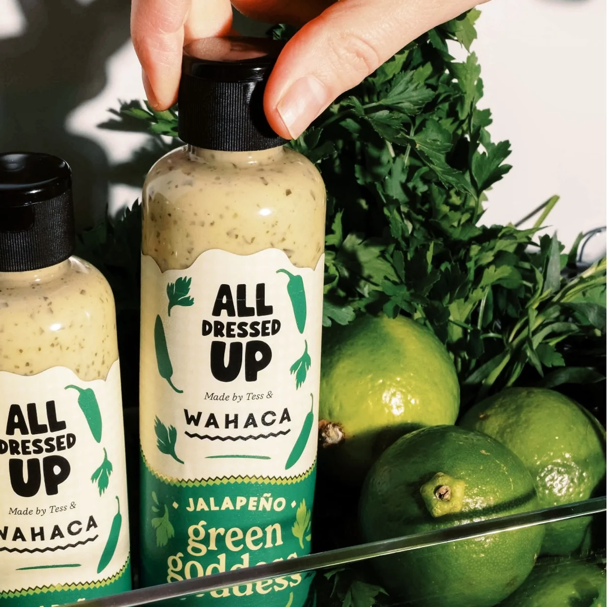Wahaca jalapeno green goddess dressing bottles with limes and coriander